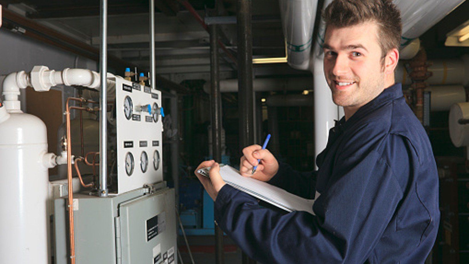 Picture of a HVAC technician inspecting a furnace.