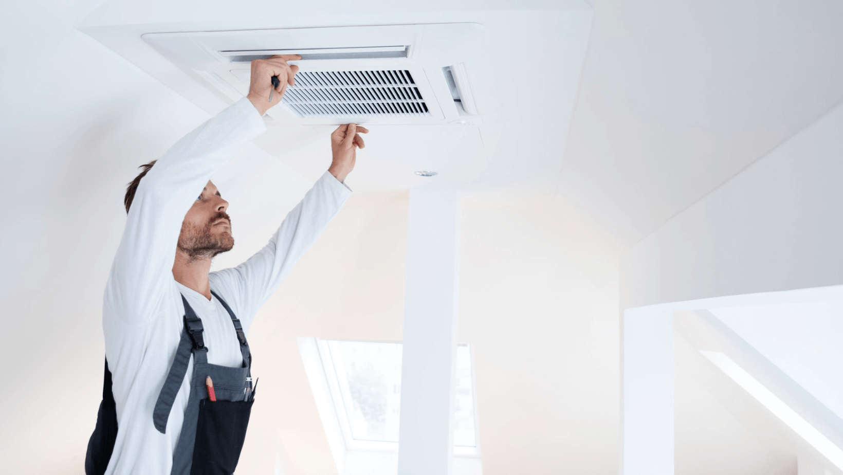 Picture of a man removing a ceiling vent.