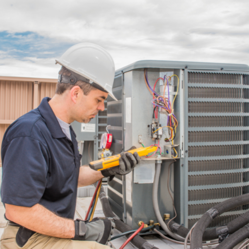 Picture of a man diagnosing an AC unit.