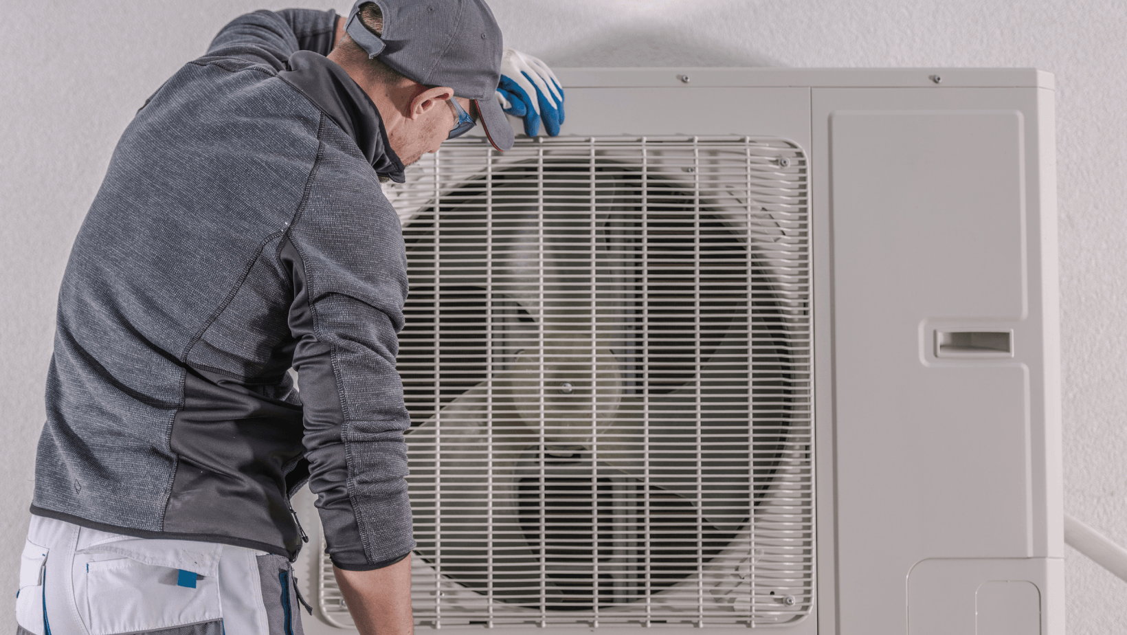 Photo of a man looking at a heat pump.