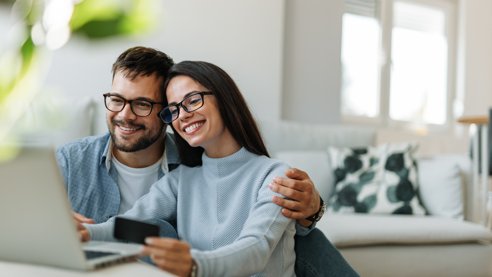 Picture of a man and woman happy looking at their computer.