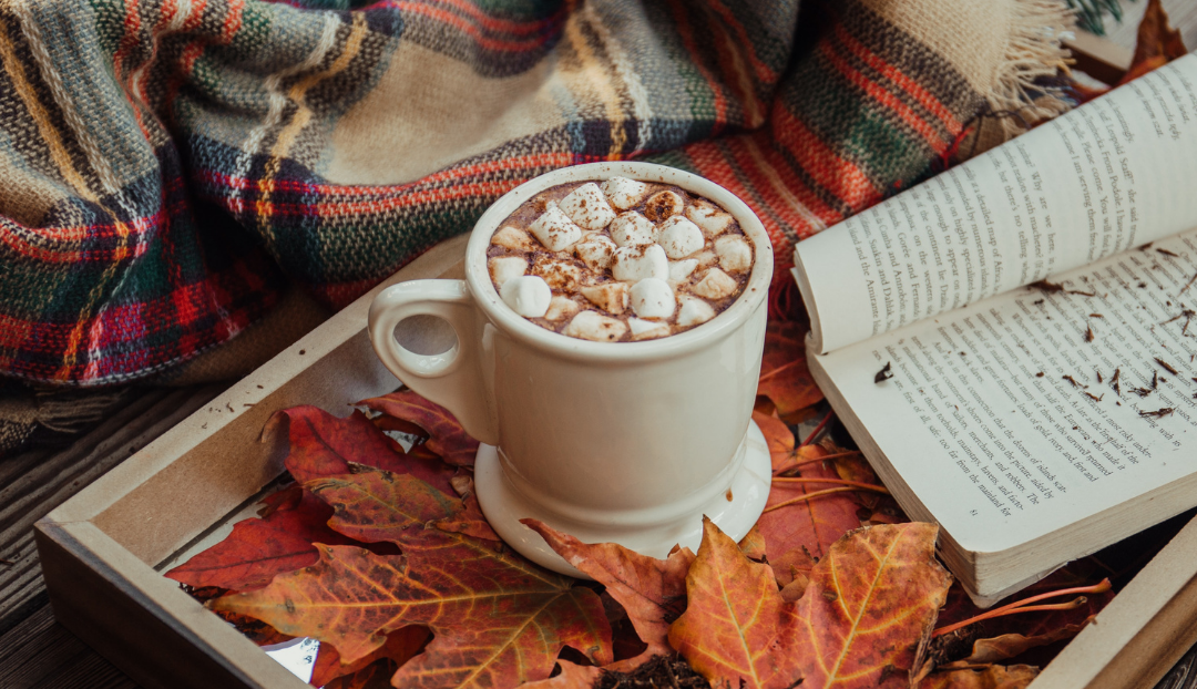 Picture of a cup of hot chocolate with orange leaves.