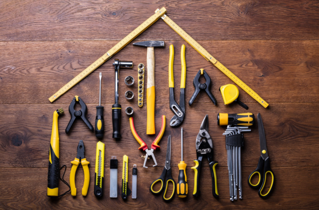 Picture of tools played out on a table in the shape of a house.