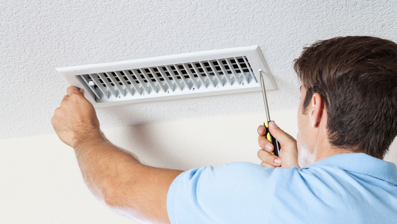 Man unscrewing an air duct.