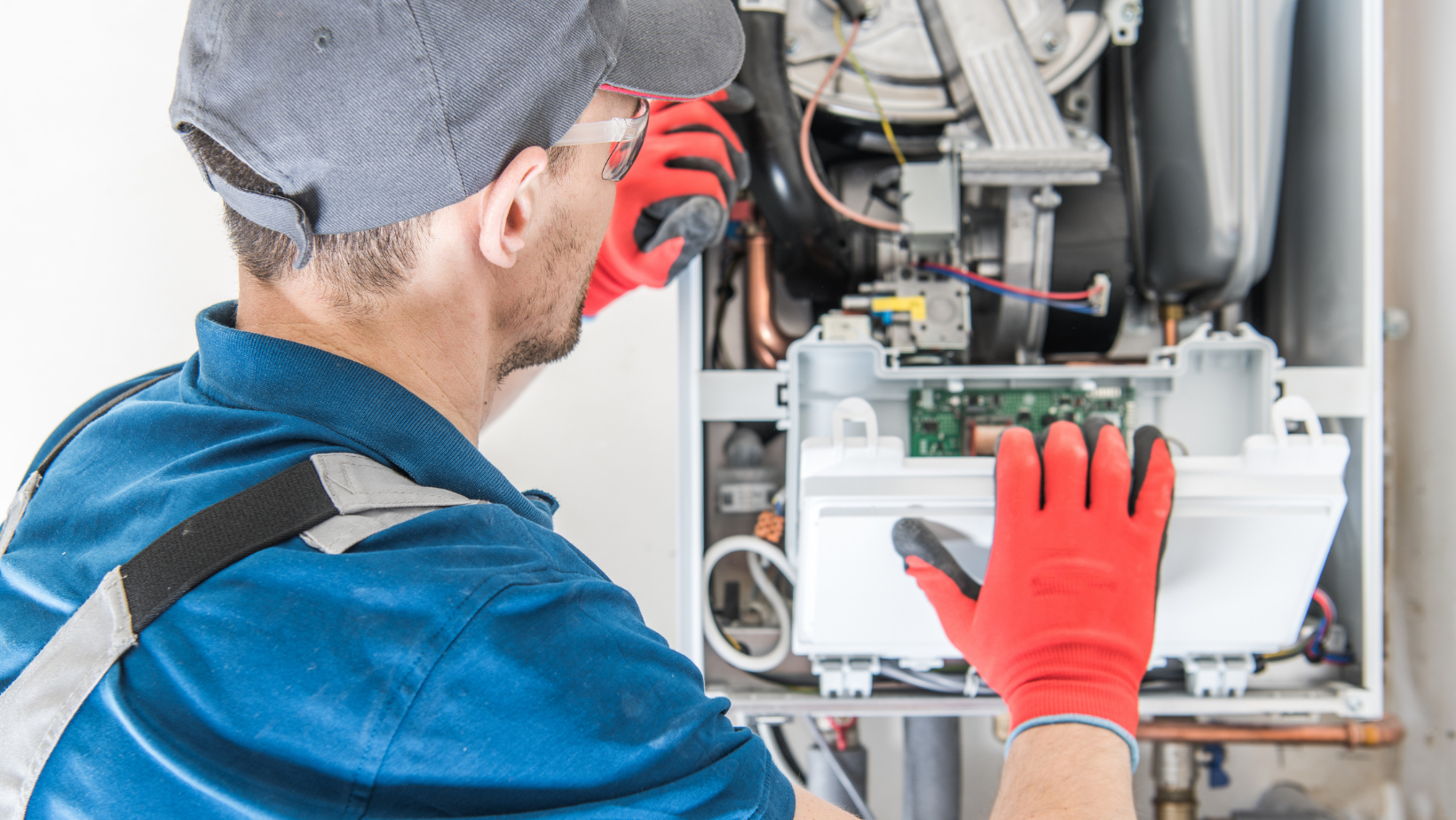 An HVAC Technician inspecting a furnace.