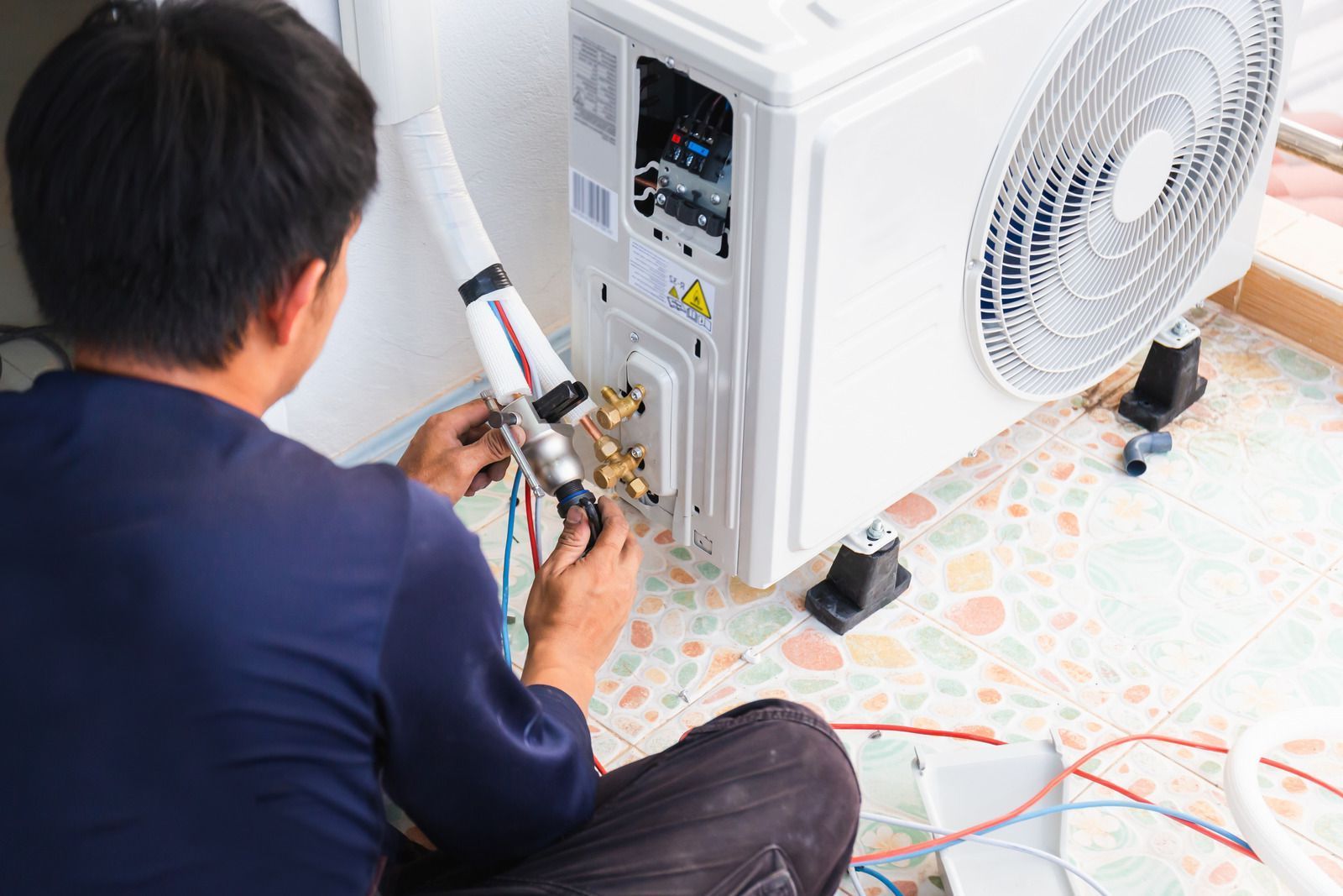 Picture of a technician installing an air conditioner.