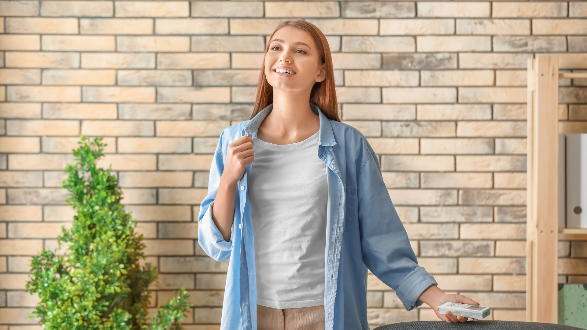 happy woman holding a remote control of AC