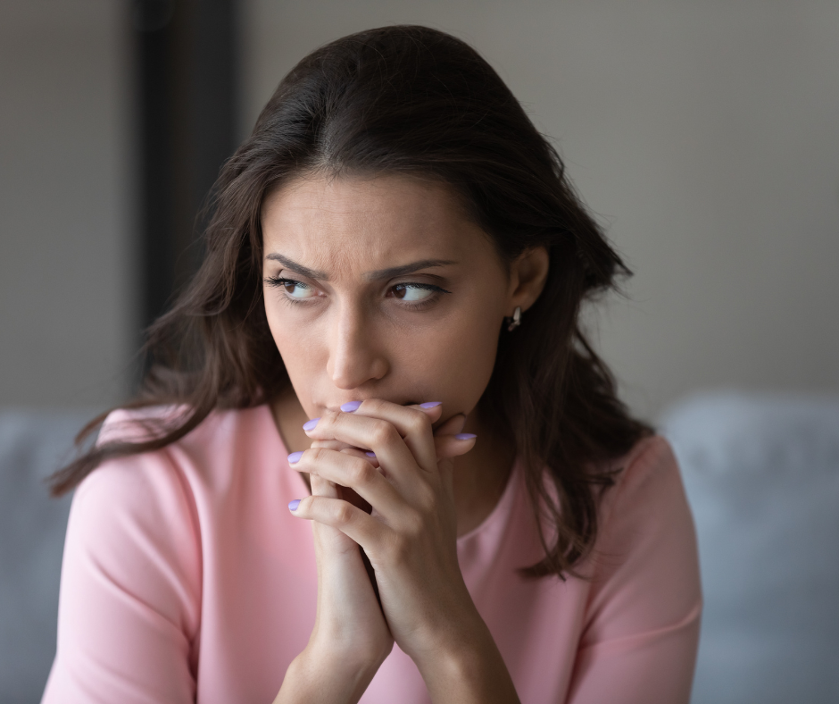 Picture of a woman sitting with a worried look on her face.