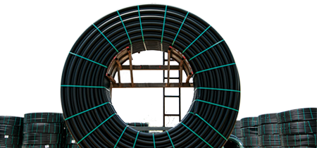 A large spool of black plastic pipe with green ties around it.