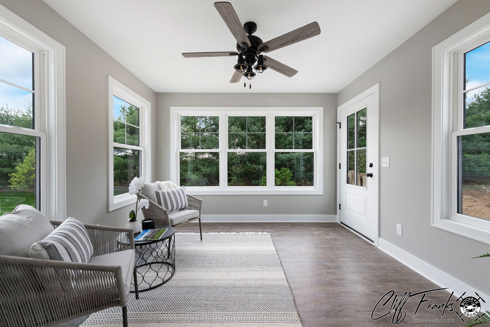 A fireplace with a stone wall and a wooden mantle in a living room.