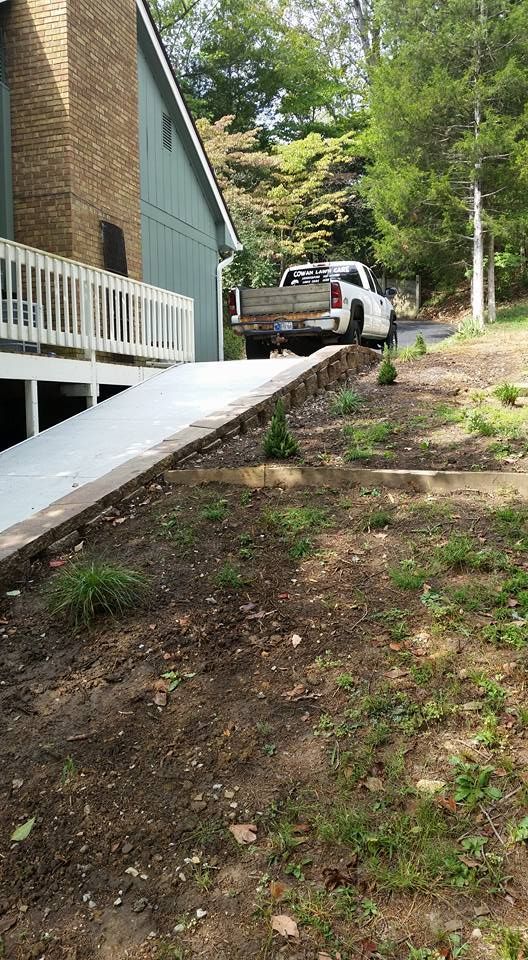 A truck is parked on a ramp in front of a house.