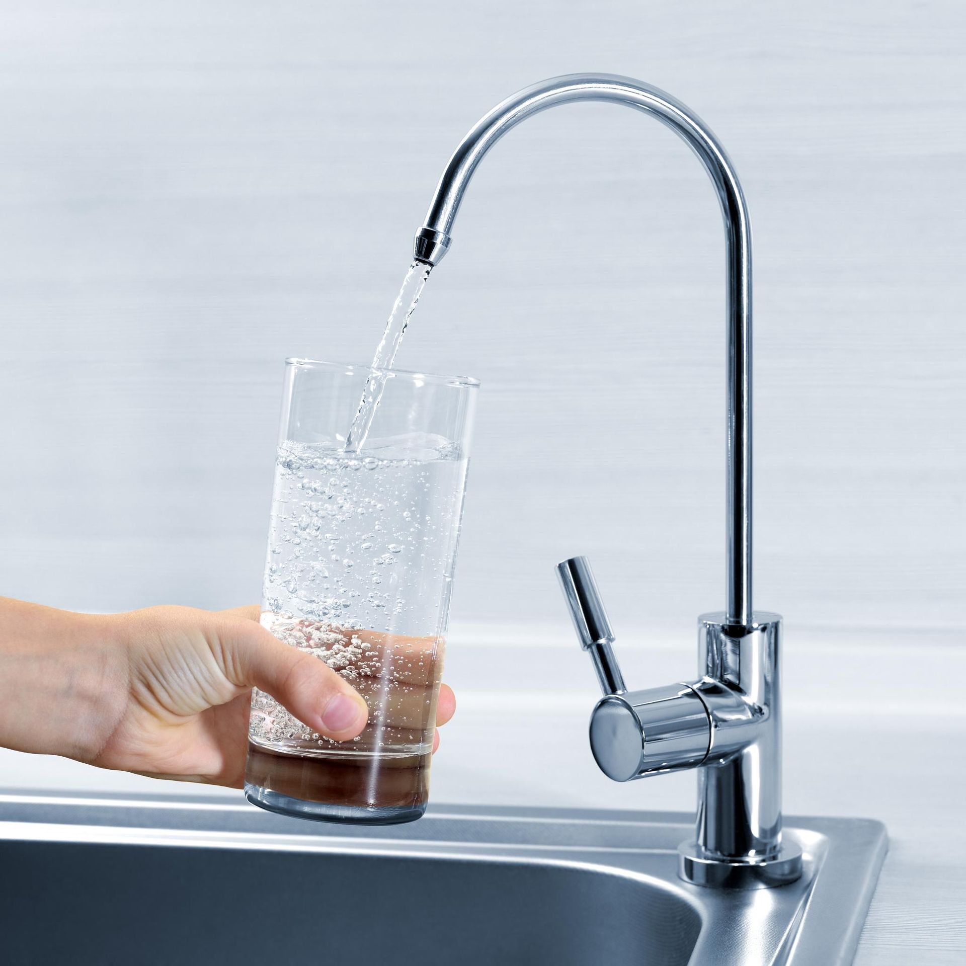 Fill the glass with water from the kitchen faucet.