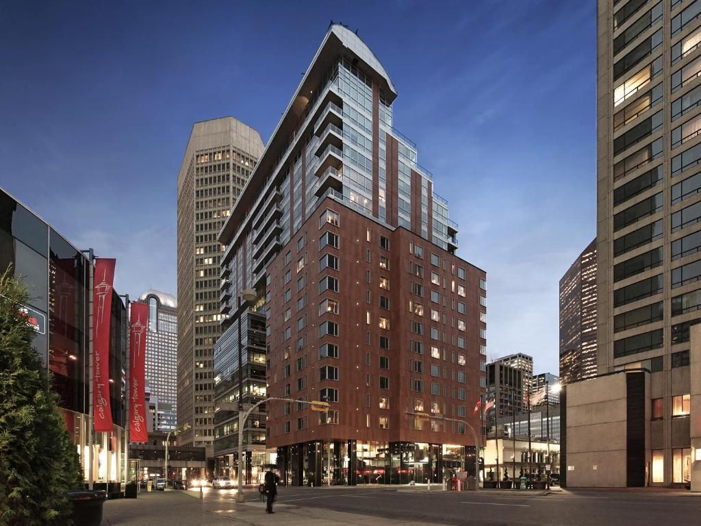 Moderne hoogbouw, verlicht bij schemering, in een stadsstraat.