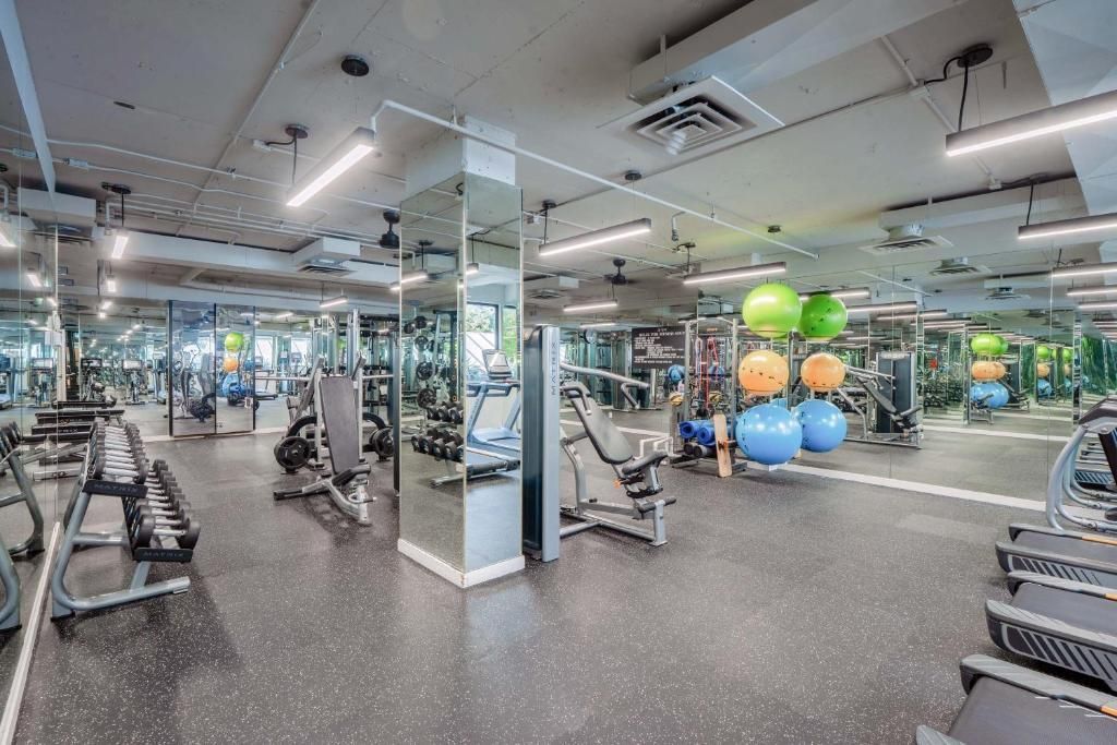 Modern fitnesscentrum met spiegels, fitnessapparaten en kleurrijke stabiliteitsballen.