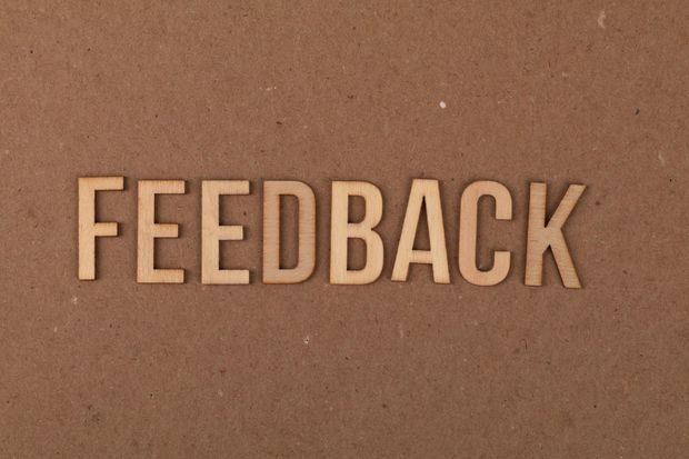 The word feedback is written in wooden letters on a brown background.