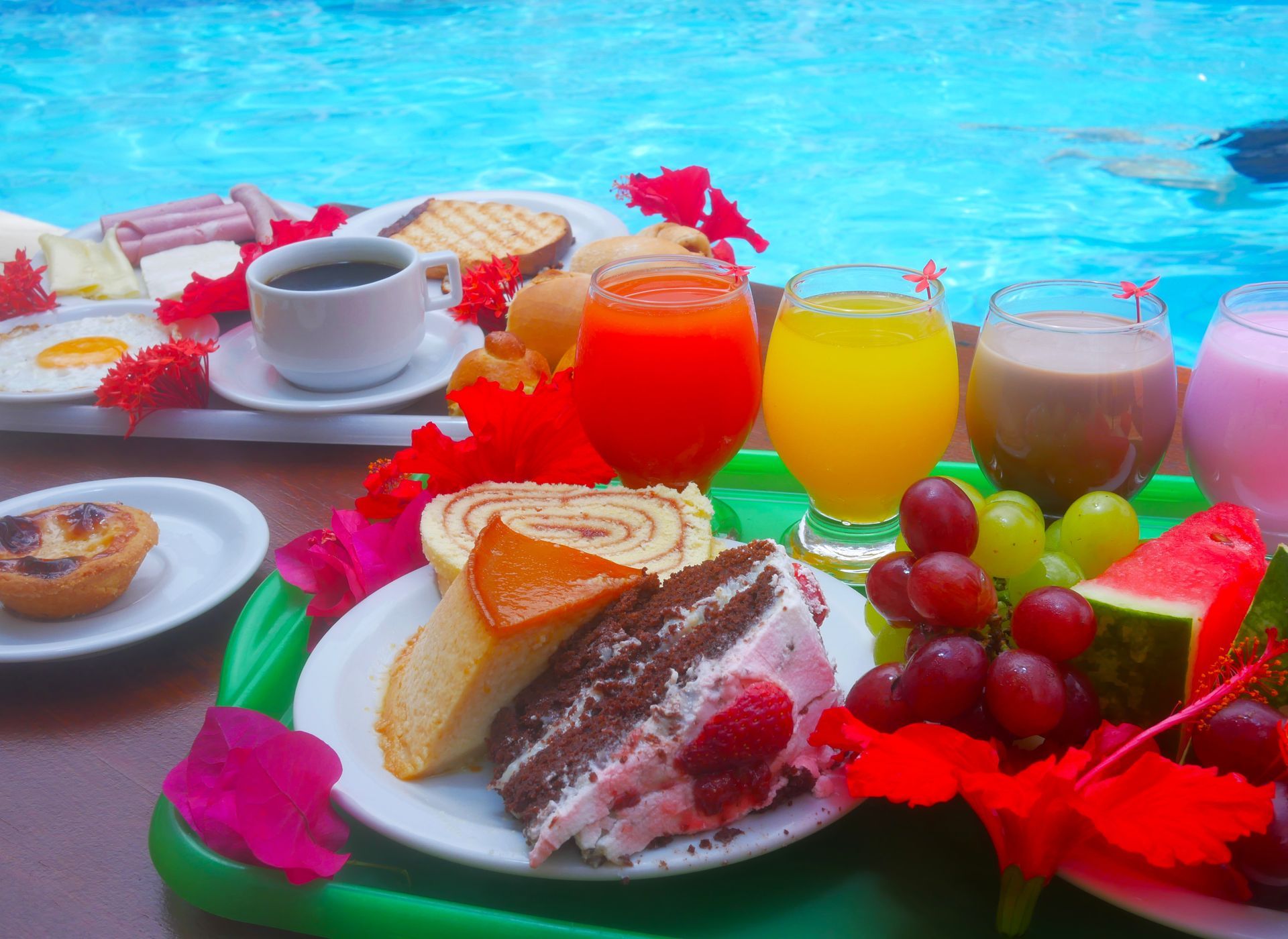 Uma grande piscina rodeada por cadeiras e guarda-sóis em frente a um hotel.