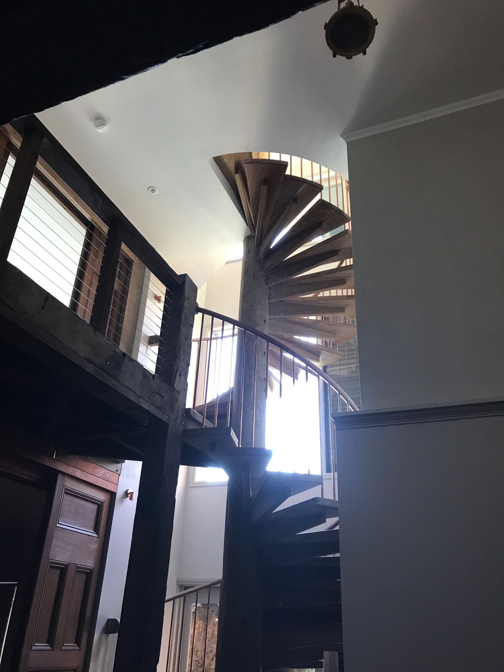 A spiral staircase in a building with a balcony