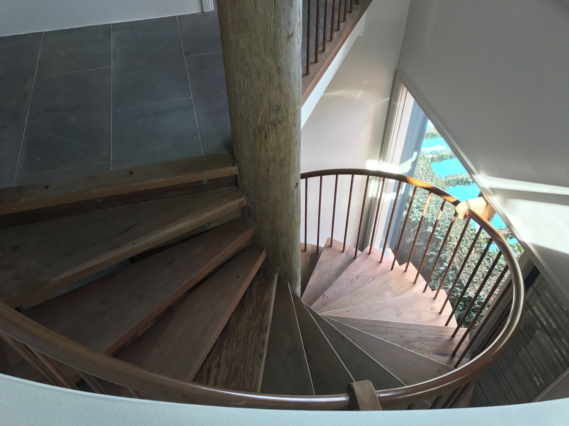 A spiral staircase with wooden steps and a metal railing