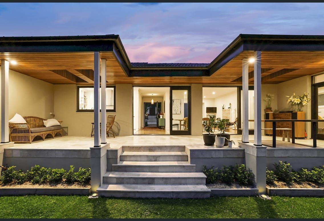 A house with a large porch and stairs leading to it.