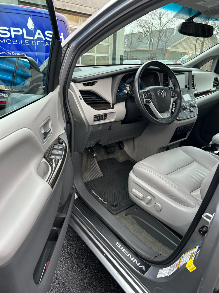 The interior of a toyota sienna is shown with the door open.