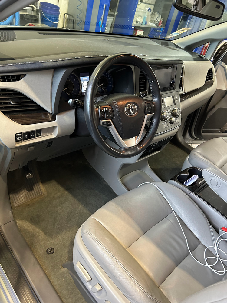 The interior of a car with a steering wheel and seats.