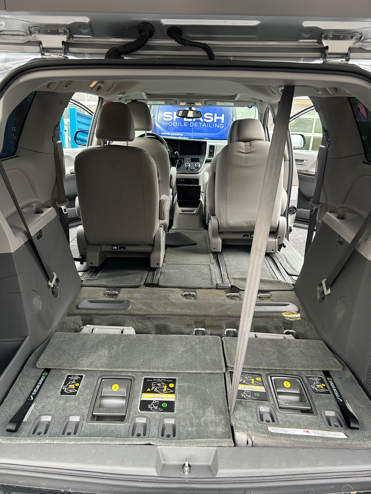 The back of a minivan with the trunk open and the seats folded down.