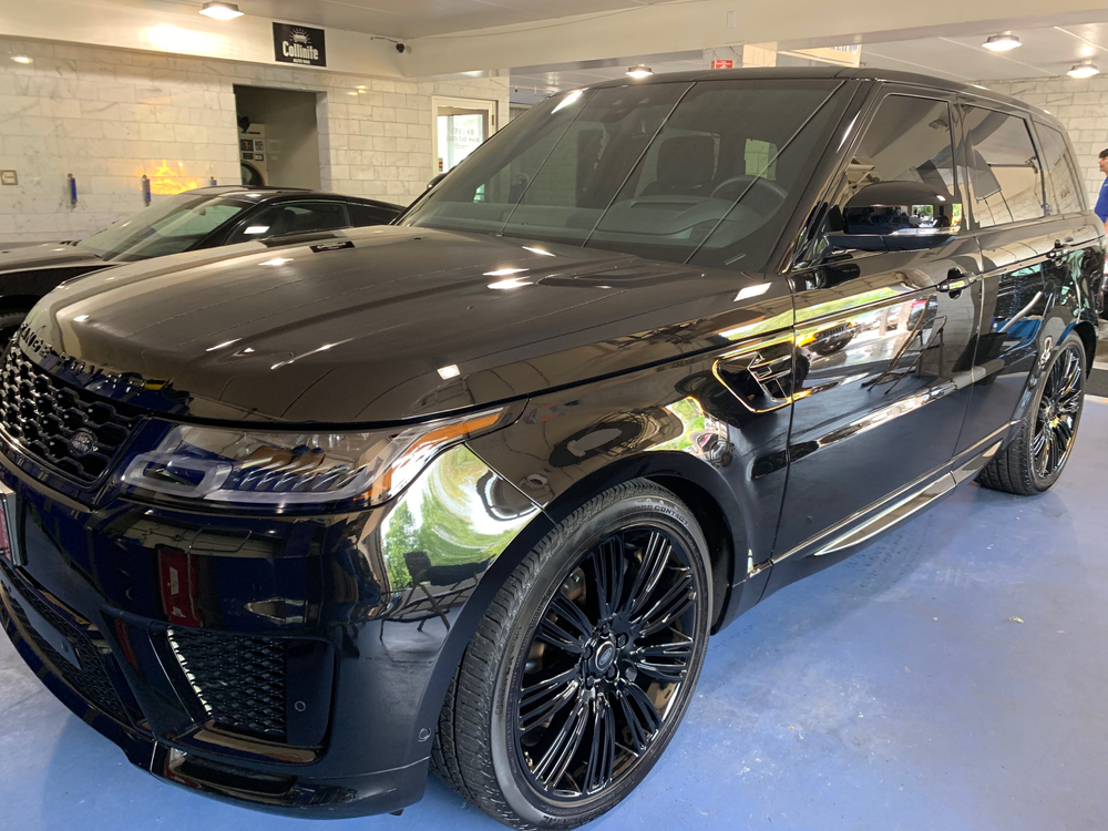 A black range rover sport is parked in a garage.