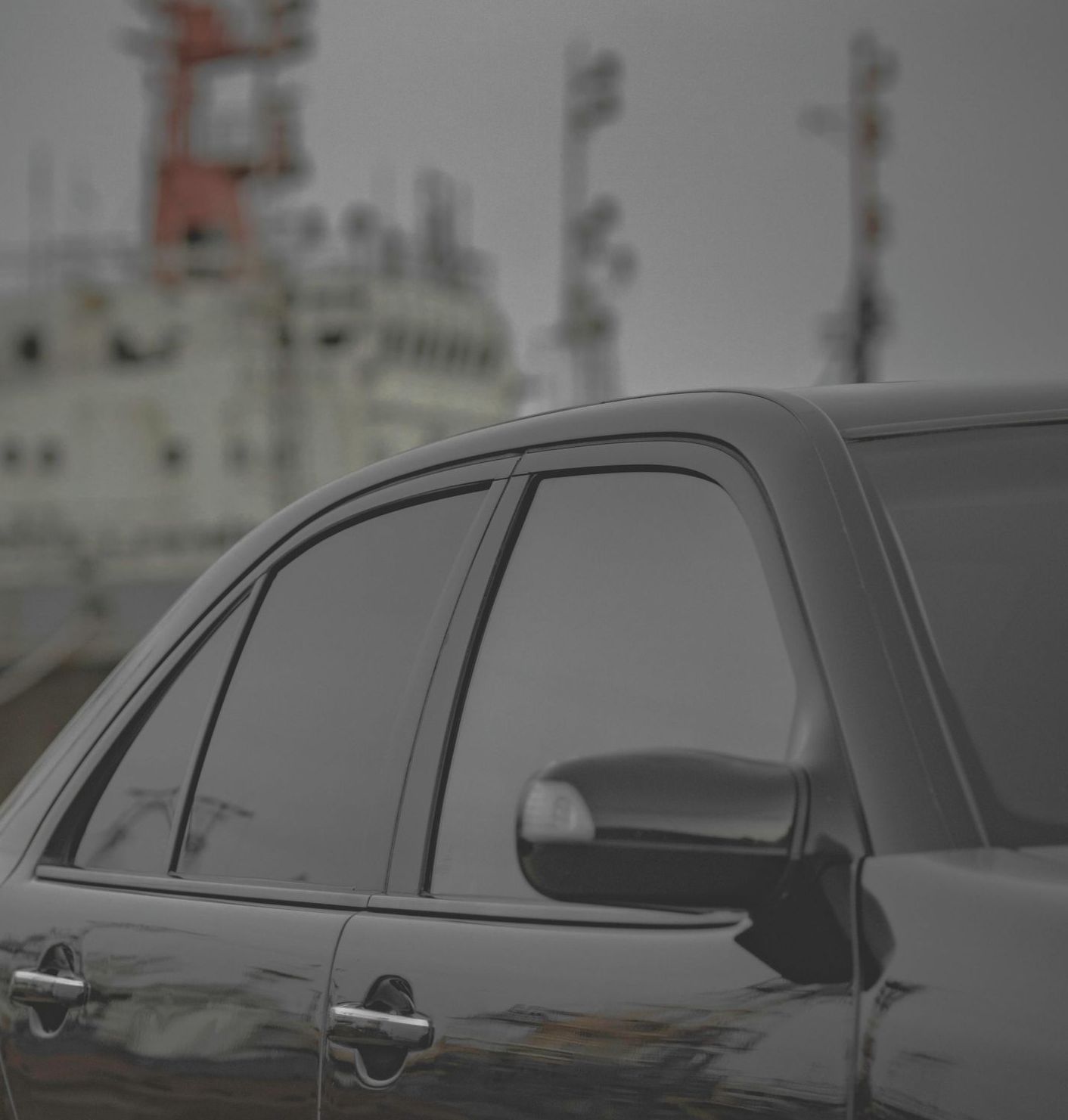 A person is installing a window tint on a car.