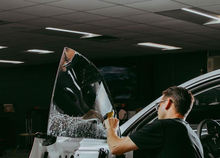 A white bmw i8 is parked in a grassy field at a car show.