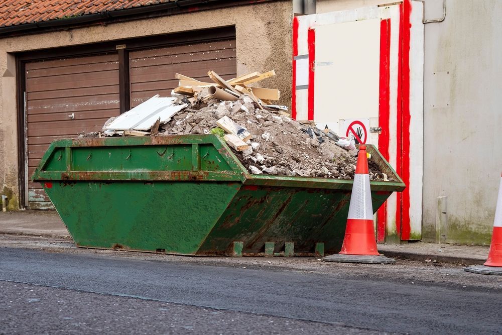 Green Dumpster Overflowing With Construction — Skip Bin Hire Sunshine Coast in Coolum, QLD