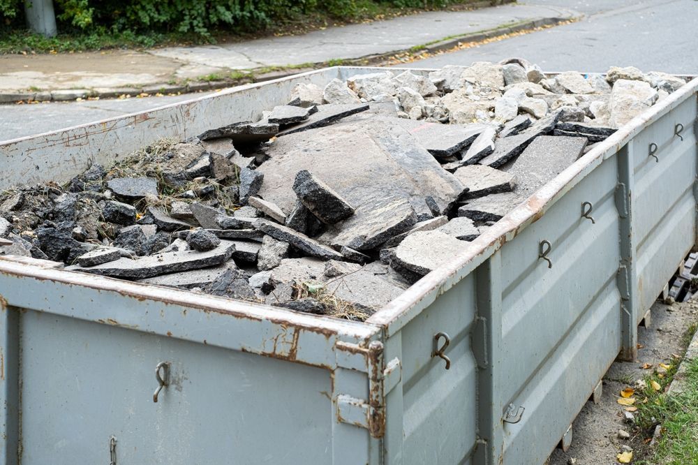 Dumpster Filled With Pieces of Broken Asphalt, Placed Near a Curb — Skip Bin Hire Sunshine Coast in Cooroy, QLD