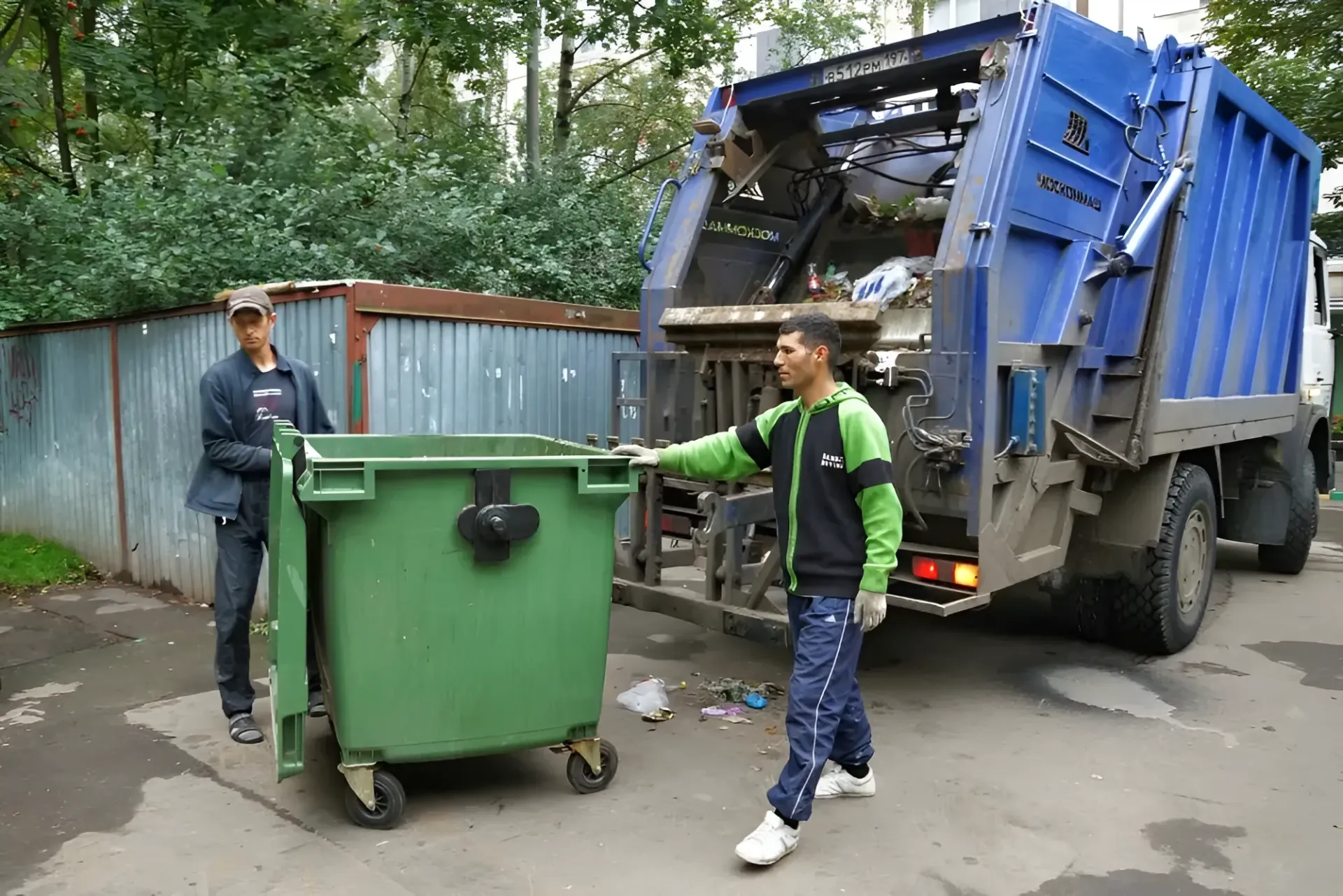 Two Sanitation Workers Emptying a Green Trash Bin — Skip Bin Hire Sunshine Coast in Kin Kin, QLD