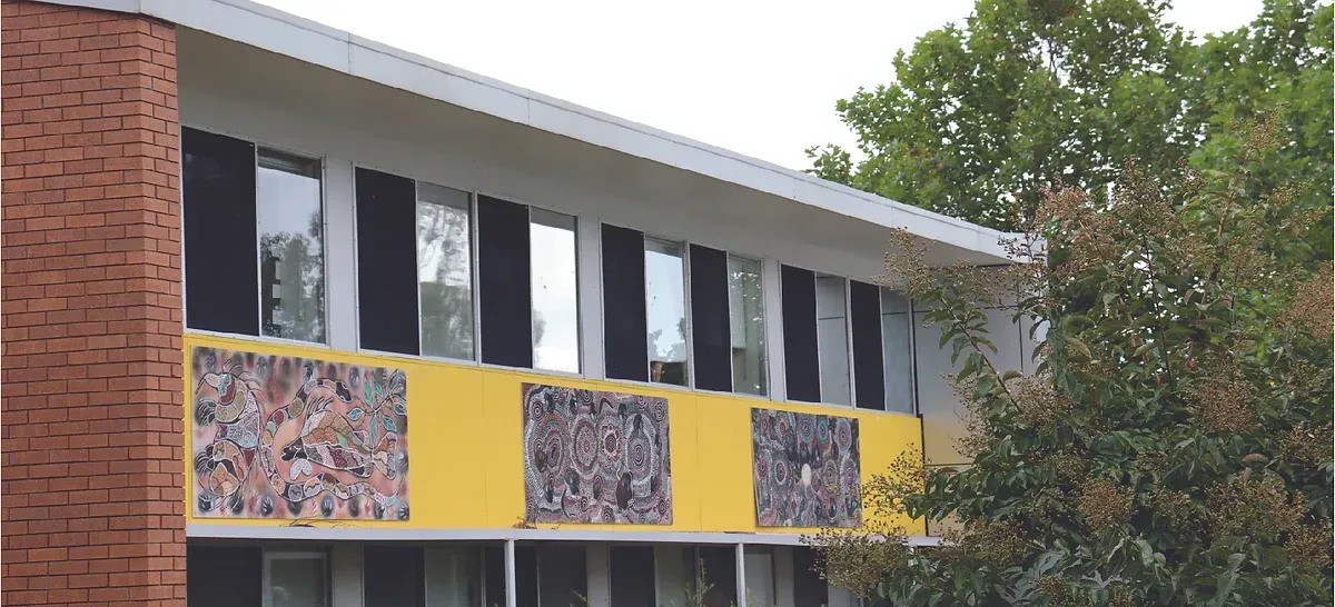 A building with a yellow and white facade and a brick chimney.