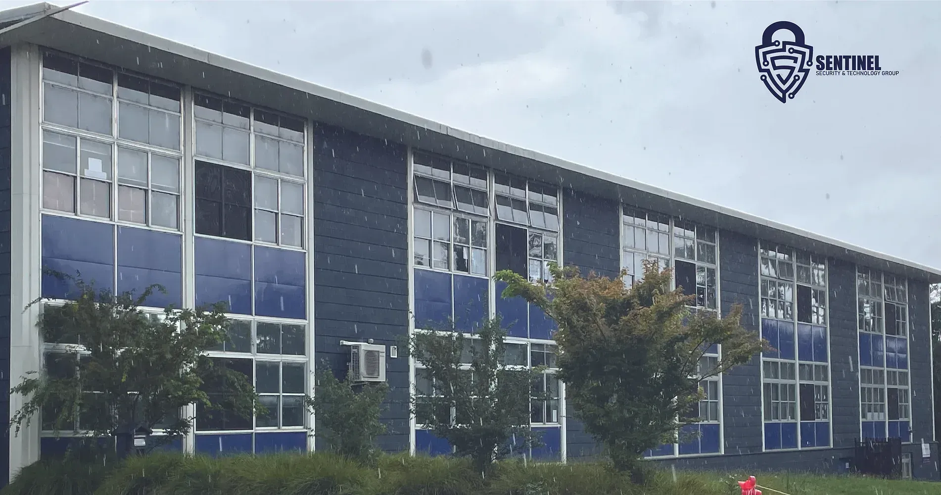 A large building with a lot of windows and trees in front of it.