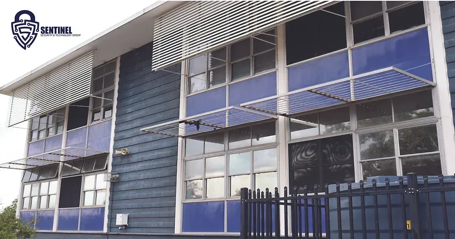 A large blue building with a fence in front of it