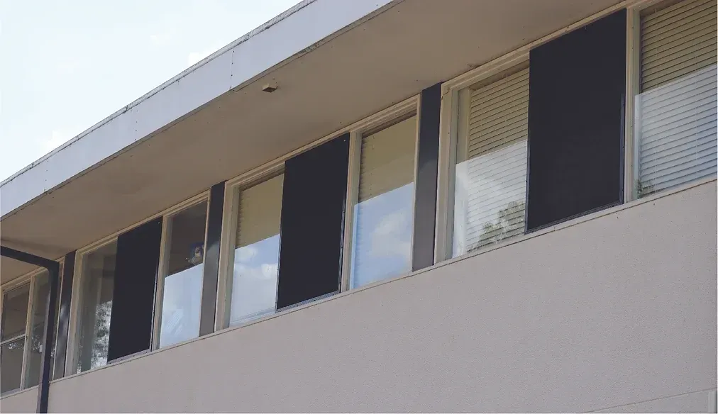 A building with a lot of windows and blinds on it.