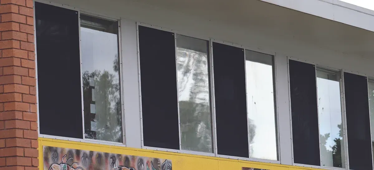 A building with a lot of windows and a yellow sign on it.