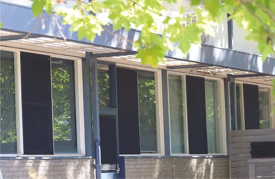 A building with a lot of windows and trees in the background