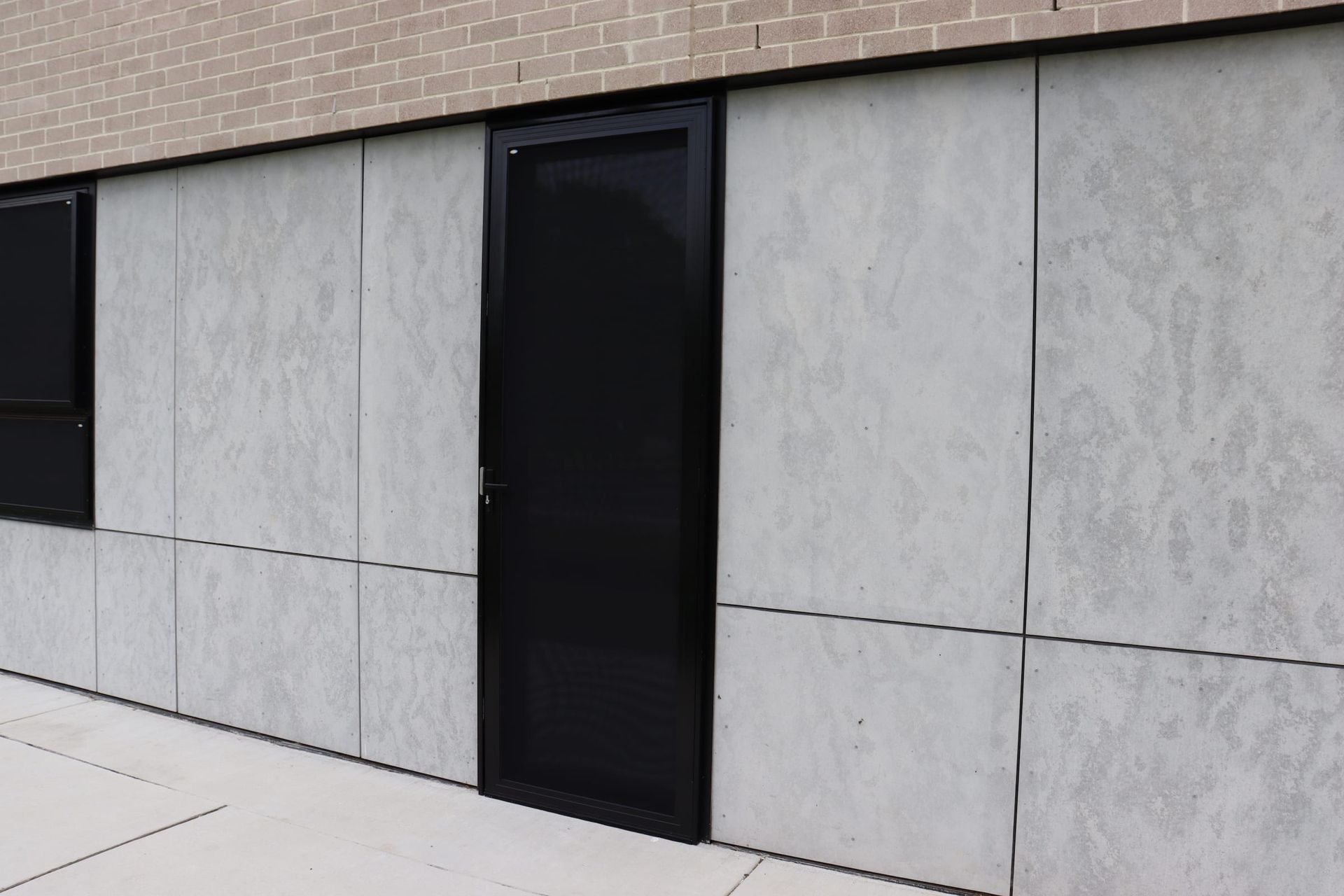 There is a black door on the side of a building.