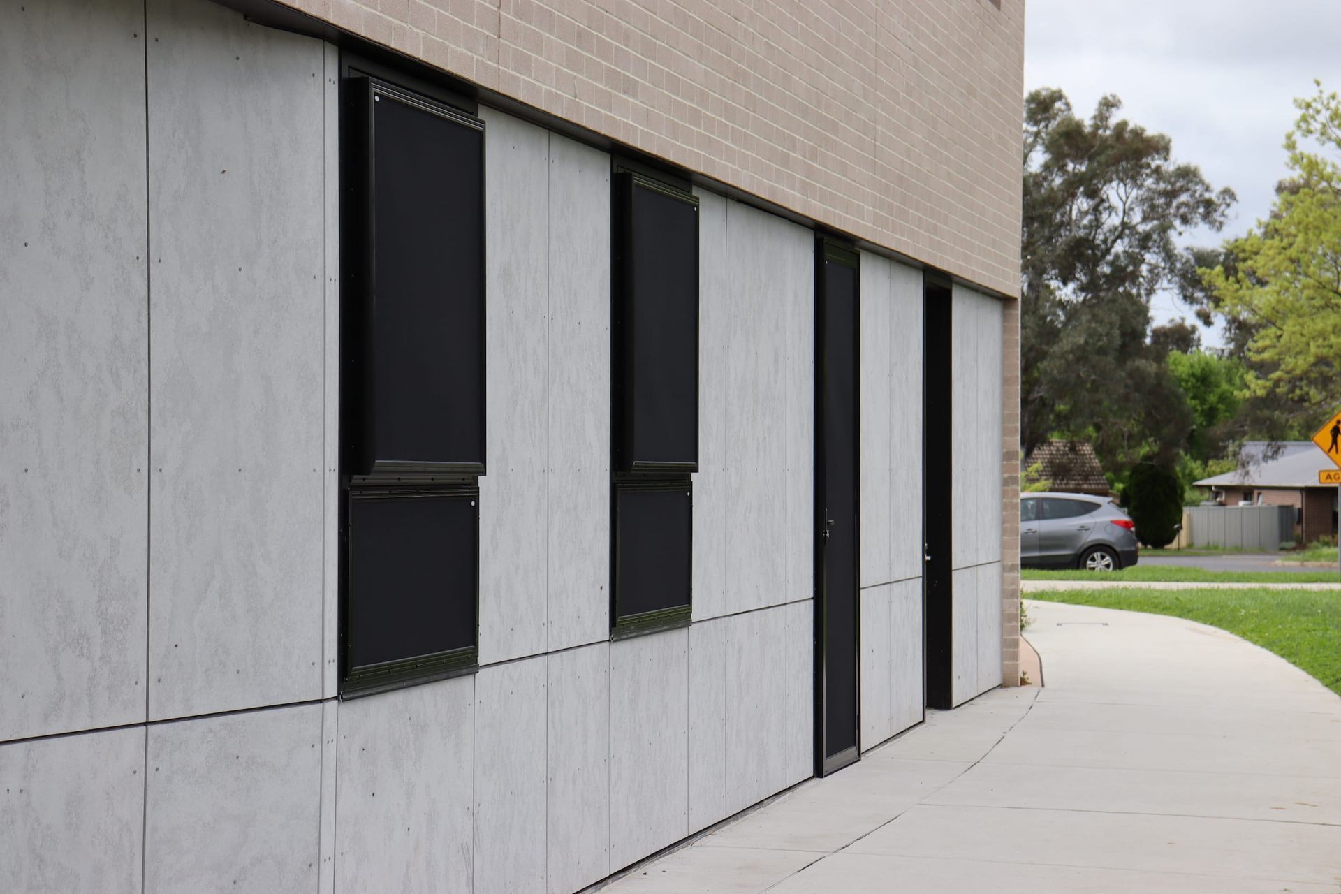 A building with a lot of windows and a sidewalk in front of it