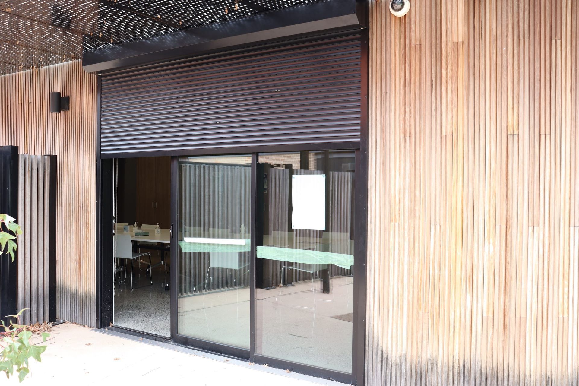 A wooden building with a large sliding glass door.