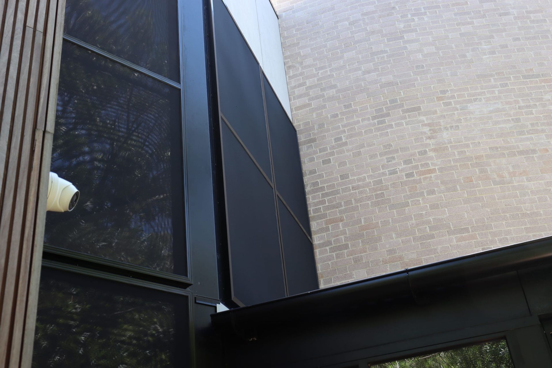 A security camera is mounted on the side of a building.