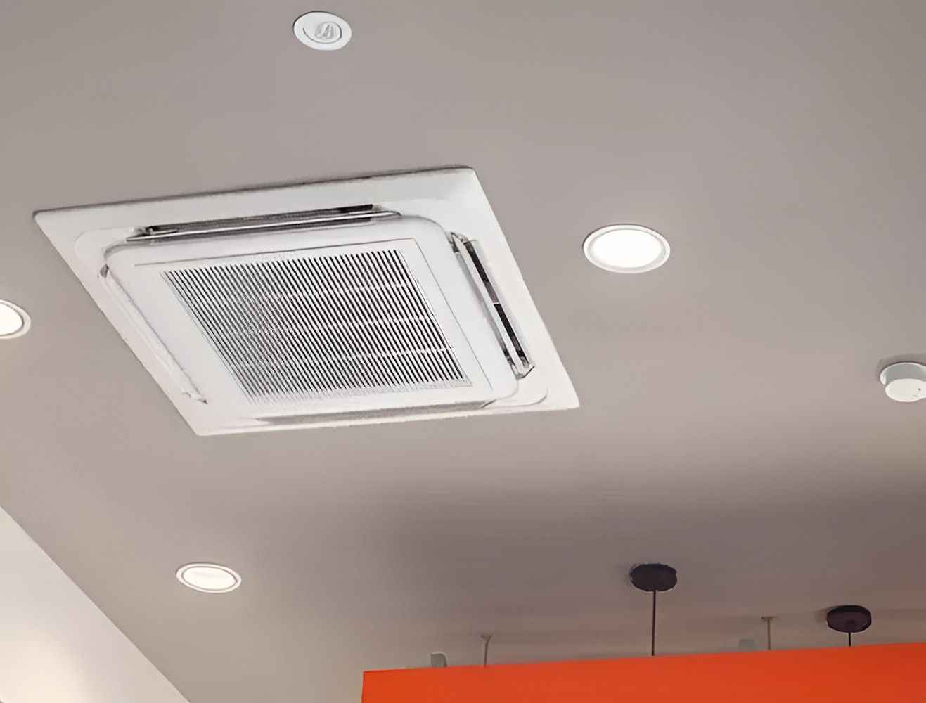 A Square Air Conditioner Is Mounted To The Ceiling Of A Room — Chris Hickling Electrical In Port Macquarie, NSW