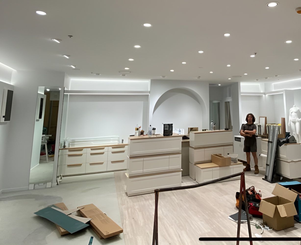 A Woman Is Standing In A Room With Boxes On The Floor — Chris Hickling Electrical In Port Macquarie, NSW