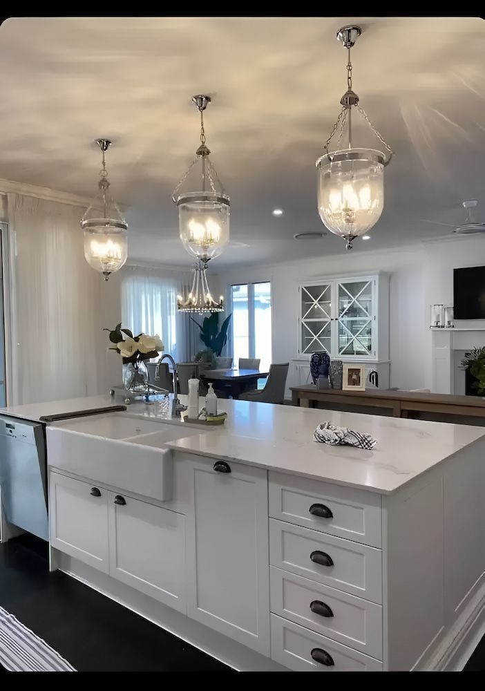 A Kitchen With White Cabinets, A Sink, And A Large Island — Chris Hickling Electrical In Port Macquarie, NSW