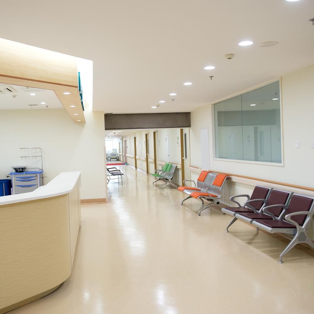 A Long Hallway in a Hospital With Chairs and a Counter — Floorgard in Wamberal, NSW