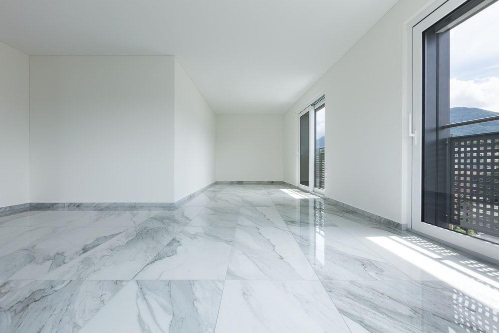 An Empty Living Room With A Marble Floor And Large Windows  — Floorgard in Wamberal, NSW