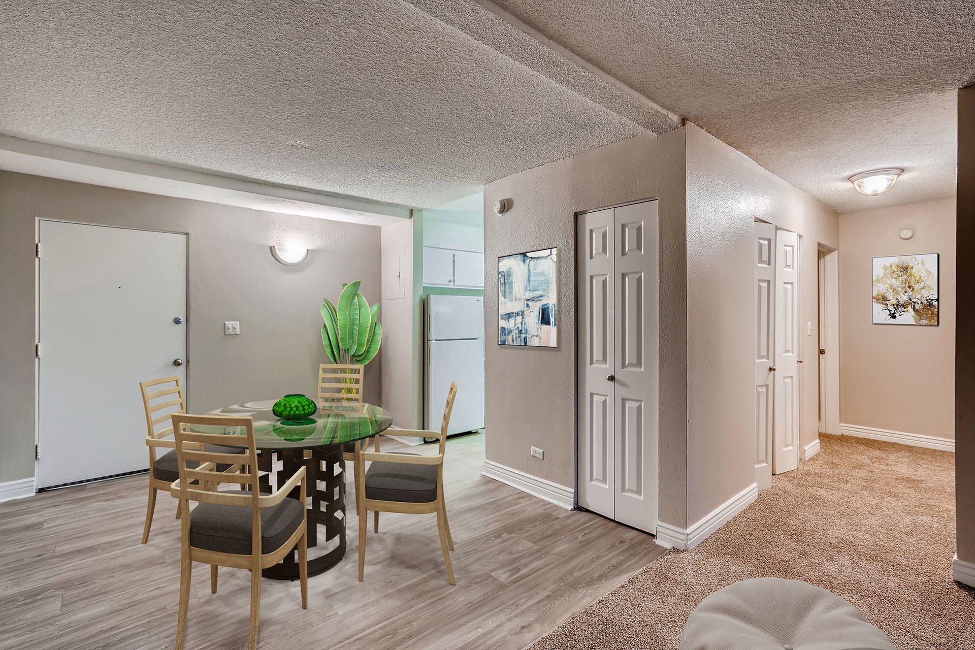 Photo showing a dining area with a hallway and kitchen in the background