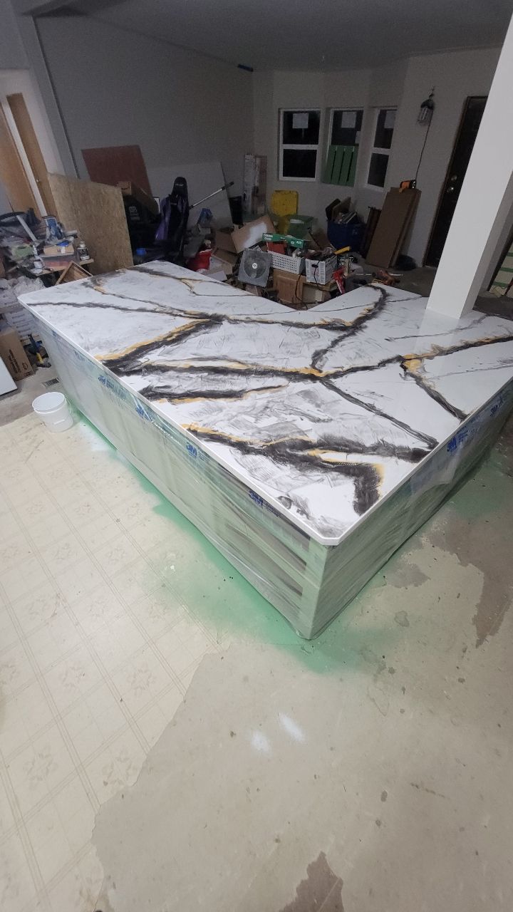 A countertop with white marble and gold accents in a workshop setting.