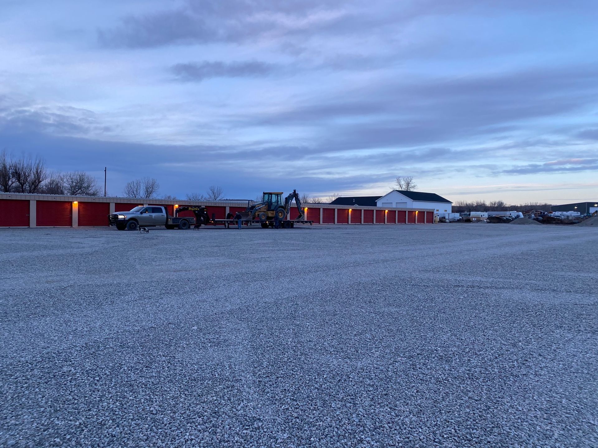 A gravel parking lot with a tractor in the middle of it.